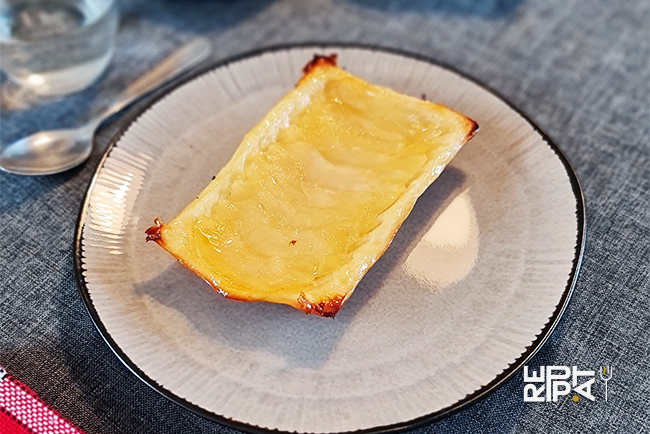 Rectangle de tarte aux pommes sur une assiette ronde de couleur grise